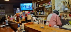 Le comptoir avec la télévision dans un petit restaurant de quartier