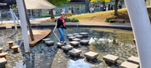 Sophie marchant sur des pierres au milieu de l'eau